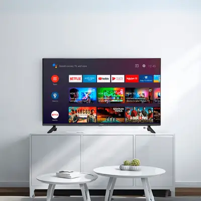 Android TV in a living room showing the Android TV home screen with streaming apps